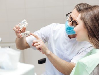 team member showing patient teeth model in Kingwood